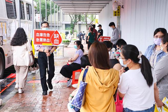 工作人员手拿板号召民眾挽起袖子，加入捐血行列，解救全台血荒之苦。（罗永铭摄）