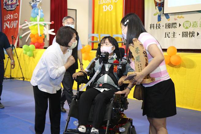 嘉义市长黄敏惠（左）送毕业礼物给珣珣，嘉勉她永不放弃学习的精神。（廖素慧摄）