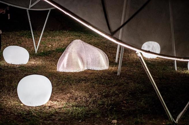  艺术家长友大辅与詹明旎的作品「脉动」融合环境空间结构与声光效果，轻盈缓慢飘舞在卫武营园区草地上，光线忽快忽慢、忽明忽暗。（图/ 中央社）
