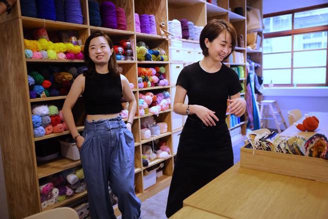 双胞胎姊妹陈亚琦（左）及陈亚筑（右）近2年在台北大稻埕设立工作室V&Jstudio，推广纺织艺术。陈亚筑16日受访时表示，毛线创作在未成形前，并不会知道成功与否，因为加针加错或是造型跑掉，都得等到织完后端详整体才能发现。（图/ 中央社）