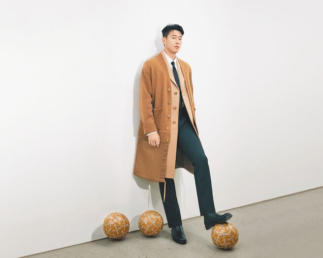 孫興慜以Burberry22早秋系列駝色外套大衣演繹正裝帥氣腳踩格紋足球拍攝畫報，讓不少粉絲敲碗品牌快上市該足球。（Burberry提供）