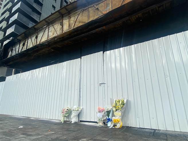 不少民眾自主送了鮮花放在陳家輪胎行圍籬前的人行道，1位家屬朋友寫上卡片「化作千風，隨風而逝」，令人萬般傷感。（陳育賢攝）