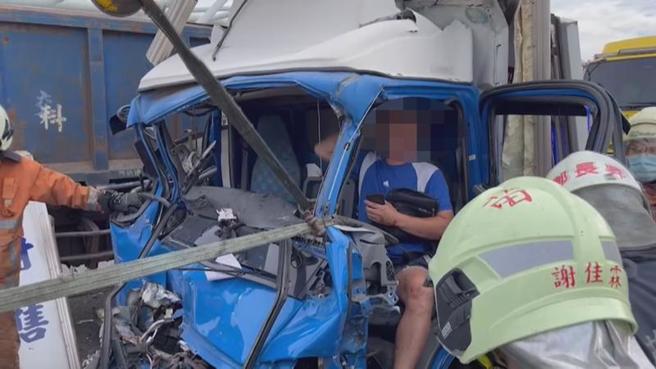 台61线西滨快速道路南下香山交流道路段17日发生货车追撞事故，造成2人受伤受困，消防救难人员动用器材、拖吊车撑开车体，将伤患送医救治。（图/ 中央社）
