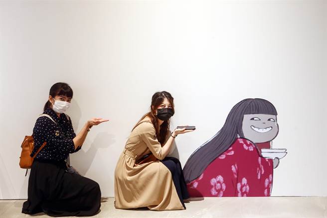 参观民眾在展场中做出与墙上图案的动作拍照留念。（邓博仁摄）
