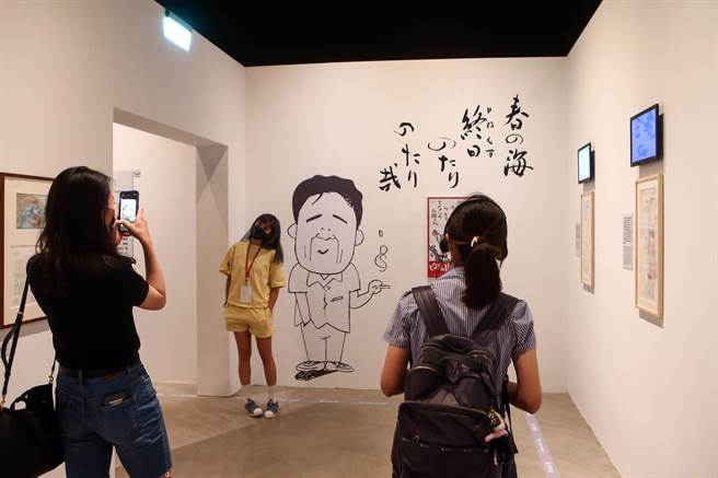 参观民眾在展场中做出与墙上图案的动作拍照留念。（邓博仁摄）