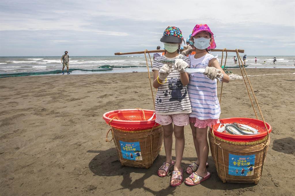 竹北市新月沙灘牽罟文化祭，小朋友高興展示捕到的「水針」等魚。（羅浚濱攝）