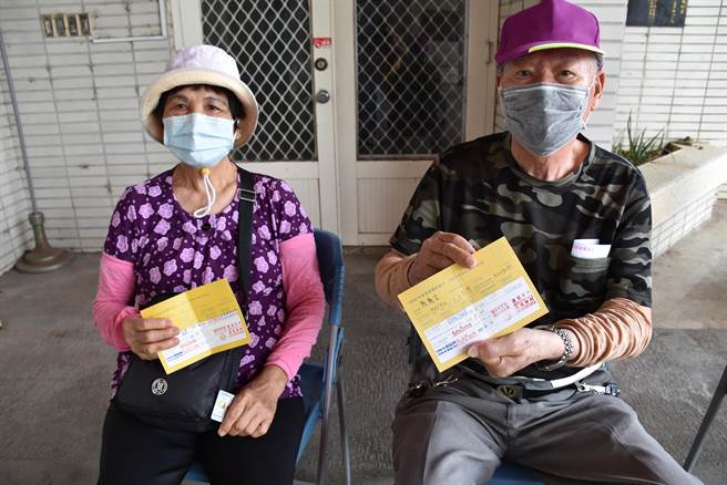 住在后龙镇的8旬老夫妇一早就到接种站排队，高兴地秀出打完3剂的接种小黄卡。（谢明俊摄）