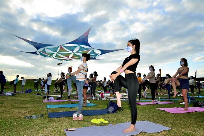 台东县政府办理「自然醒慢活祭」，近百位民眾18日在加路兰海边迎着晨曦做瑜珈，舒展筋骨，放松大脑。（庄哲权摄）