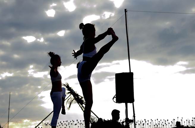 台东县政府办理「自然醒慢活祭」，近百位民眾18日在加路兰海边迎着晨曦做瑜珈，舒展筋骨，放松大脑。（庄哲权摄）