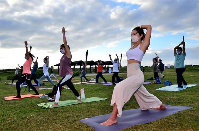 台东县政府办理「自然醒慢活祭」，近百位民眾18日在加路兰海边迎着晨曦做瑜珈，舒展筋骨，放松大脑。（庄哲权摄）