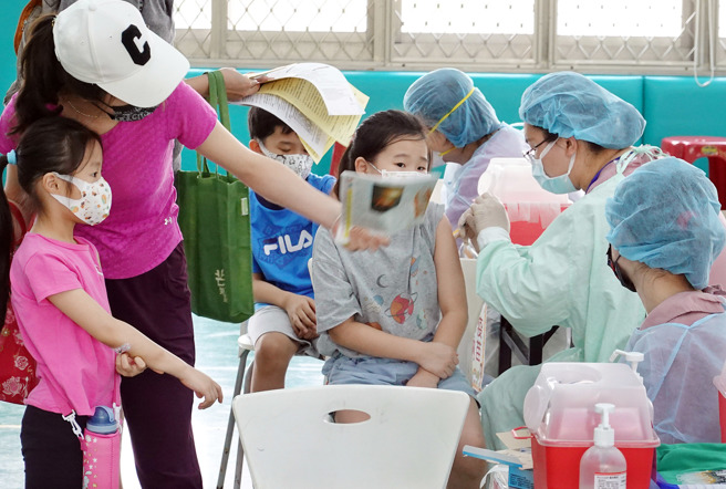 北市万华区西门国小18日接种莫德纳与BNT儿童疫苗，不少学童们神情自若地接受施打，还有小朋友和同侪们有说有笑。（姚志平摄）