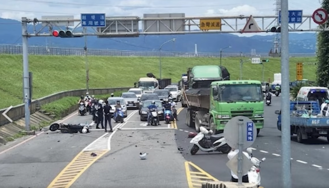 新北市环堤大道14日1名重机骑士疑似在违规跨越双黄线逆向时，一度被前车挡住视线，竟与对向1辆机车对撞，对撞瞬间零件喷飞，惊悚影片曝光。（翻摄自脸书记者爆料网）