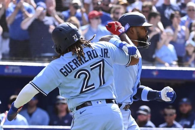 蓝鸟小葛瑞洛(左)与队友贺南德兹庆祝全垒打。（美联社）