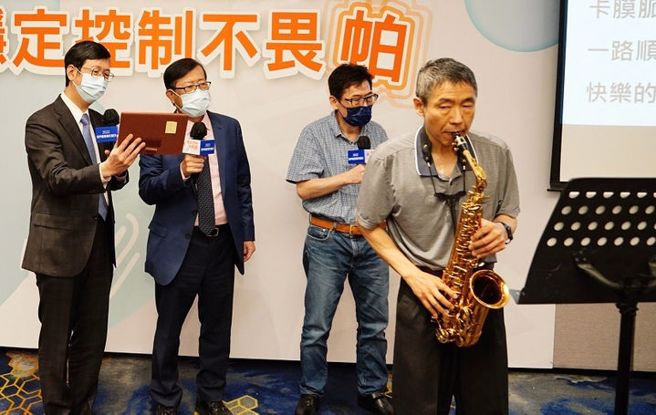 林先生（右）吹奏萨克斯风，Andy（右二）与医师配合演唱《快乐的出航》。(图片来源 / 陆教授神经科诊所提供）