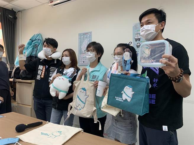 民眾党推出吉祥物「眾宝」周边纪念小物颈枕、帆布袋、保温杯等，民眾参加「全台大眾走」活动参加抽奖，就有机会获得纪念小物。（林缙明摄）