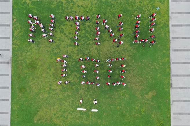 台師大百年校慶鐵騎環島3天抵達嘉義市文化中心前方廣場，大家聚集排出「NTNU 100」字樣，共同完成空拍壯觀畫面。(台師大提供／李侑珊台北傳真)