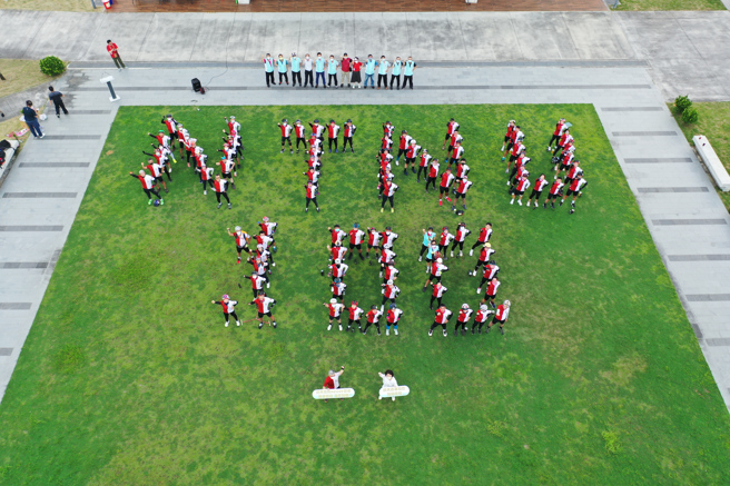 台师大百年校庆铁骑环岛3天抵达嘉义市文化中心前方广场，大家聚集排出「NTNU 100」字样，共同完成空拍壮观画面。（台师大提供）