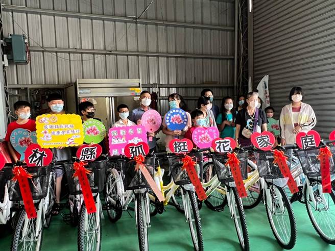 关怀弱势学子，云林县虎尾镇长丁学忠（左五）赠送夜光天使班自行车。（孤挺花家庭关怀协会提供／张朝欣云林传真）