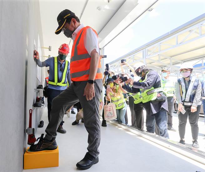 王国材穿上钢头鞋，在劳动安全训练设施区，体验钢头鞋防止物体坠落。（陈麒全摄）