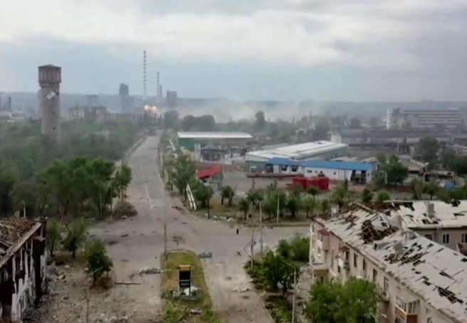 北顿内茨克市内一景，远方的是化工厂，而近处的建筑都已残破。(图/ukrinform)