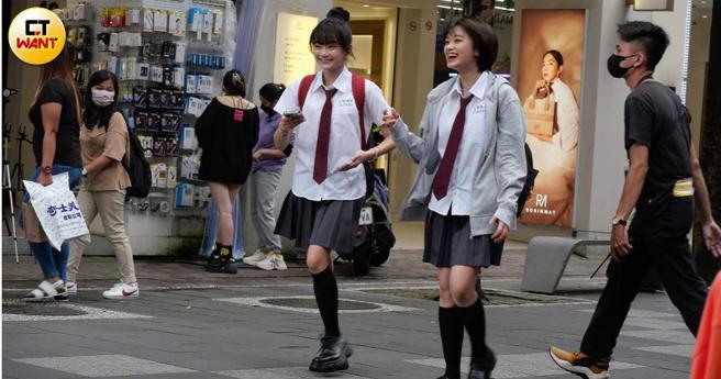 綁著丸子頭的邵奕玫與友人在街頭露出開心笑容。（圖／本刊攝影組）