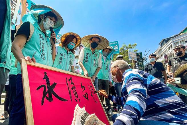 民眾党今天在宜兰启动「全台大眾走」，出发前壮围乡新南村长叶庆文题字写下「永续台湾、世代共行」的活动理念。（李忠一摄）