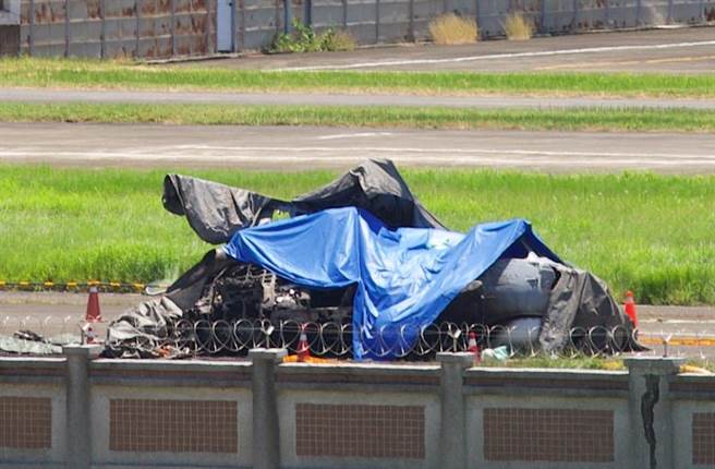 军方用大型帆布将坠毁的直升机盖住。（袁庭尧摄）