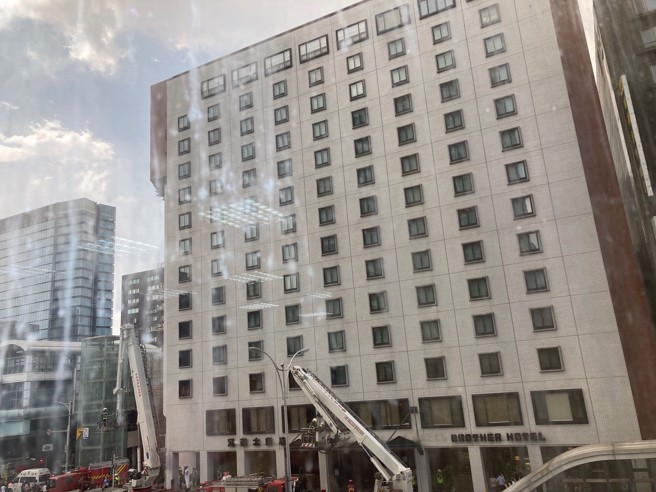 北市兄弟大飯店23日下午1時發生火災，不少民眾直擊雲梯車到場待命。（翻攝自PTT）