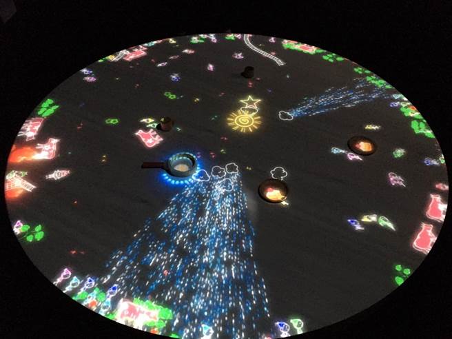 「小人所居住的桌子」在桌子上放置物品来与小人们互动，随着每个新物件的放置，小人们的运动路径及生活发生变化；它们通过跳跃，攀爬和滑动来与物体相互作用。（崔正纲摄）