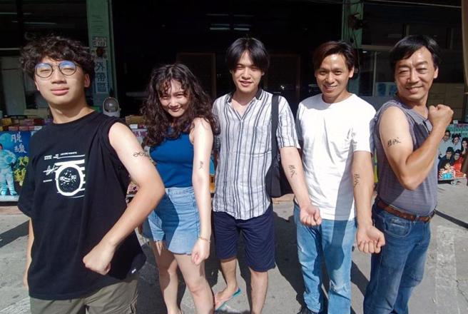 甘草艺人脱线日前病逝，在台东跟着他一起生活、长大的孙子将「脱线」亲笔签名字样刺在自己手臂上，就像阿公从未离开，一直陪伴他们，连脱线的儿子陈嘉成（右1）也加入行列。（图/ 中央社）