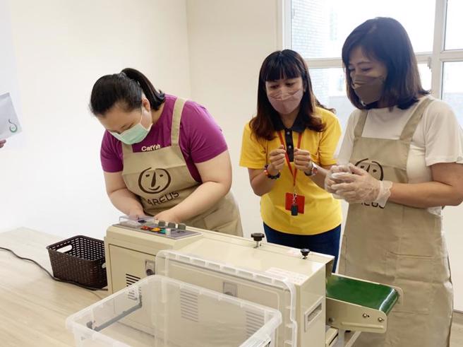  新竹市政府23日表示，市府携手喜憨儿基金会，打造「滤挂咖啡包装」课程，支持憨儿的技能教育，盼能培养一技之长，也学习融入社会。副市长沈慧虹（右）说，课程更为身障者提供「易读版」作业流程，培力憨儿手作能力。（图/ 中央社）