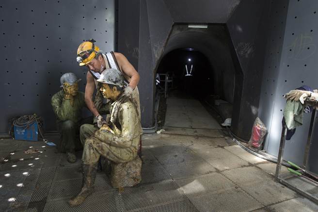 本山五坑内原本摆设多尊矿工雕像呈现早年矿工工作情形，为了便于翻修坑道，老矿工暂时将它们搬到坑道口。（黄子明摄）