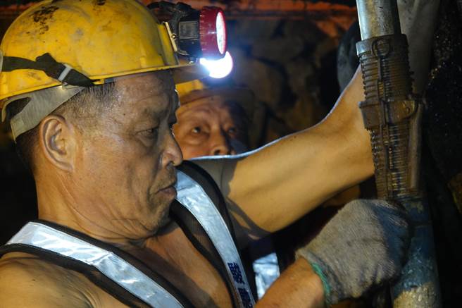 老矿工林聪明（见图）神情专注在本山五坑用支架支撑坑道顶部。（黄子明摄）