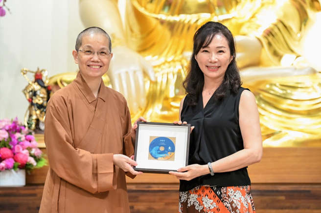 佛光山中区总住持觉居法师（左）致赠讲座纪念光碟予讲师李佳芬（右）。(图／佛光山惠中寺提供)