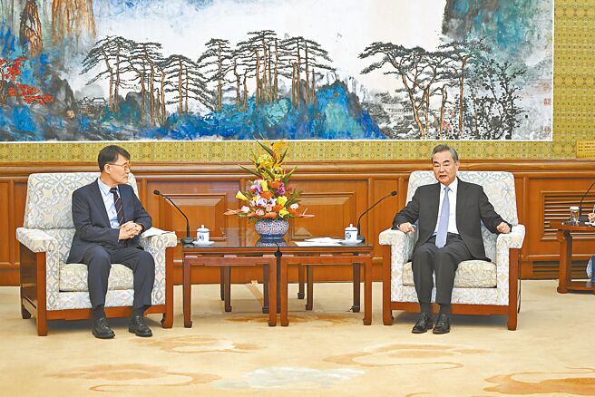 中國外長王毅（右）22日會見即將離任回國的韓國駐華大使張夏成。（新華社）