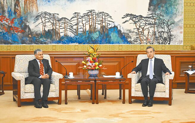 中國外長王毅（右）22日會見印度新任駐華大使羅國棟。（新華社）