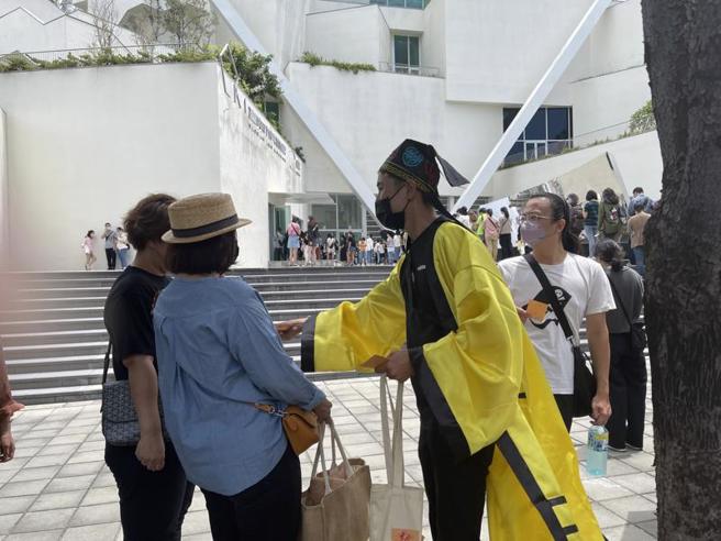 台南市美术馆2馆「亚洲的地狱与幽魂」25日开展，场馆内外挤爆，还有人穿着道士服发放符咒安人心。（图/ 中央社）