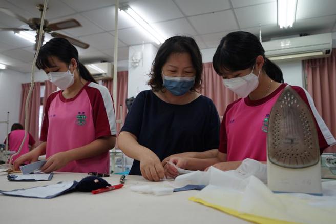 花蓮縣私立海星中學服裝設計學程老師鍾佩卿（中）27年來犧牲假日、休息時間加班指導學生創作，獲教育部111年杏壇芬芳獎肯定。（圖/ 中央社）