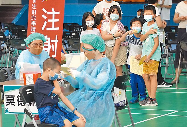 台北市銘傳國小23日施打第2劑兒童新冠疫苗，已接種完的小朋友們在留觀區觀看其他小朋友打針。（姚志平攝）