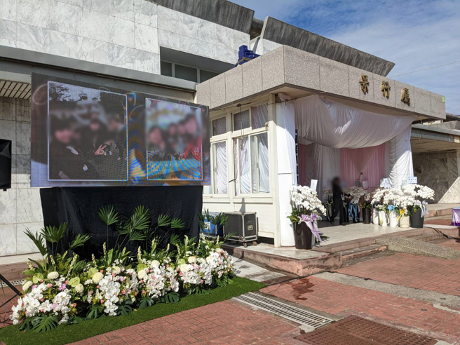 新竹正義輪胎行26日舉行告別式，廳外的電子螢幕以投影片方式輪番呈現亡者生前的照片。（葉宣婕攝）