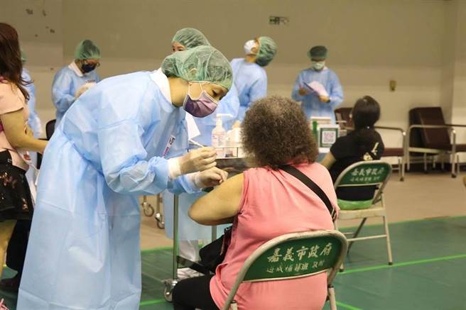 嘉义市港坪体育馆接种站医护人员为长者接种第4剂疫苗。（廖素慧摄）