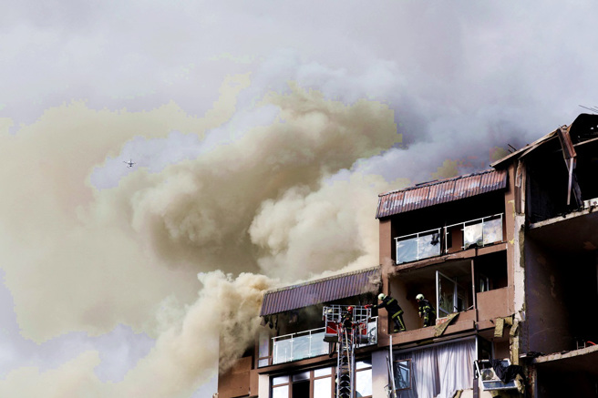 烏克蘭首都基輔26日清晨遭到俄羅斯飛彈攻擊，一棟民宅大樓遭擊中後起火、冒出濃煙。（圖／路透社）