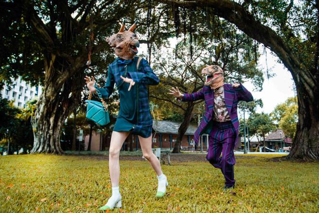 恐龍的皮團員三角龍、暴龍分別以以Vivienne Westwood Fan Shirt Dress，4萬9600元、印花襯衫1萬1900搭配紫色條紋西裝，展現屬於他們的時尚魅力。（攝影/石智中、服裝Vivienne Westwood、三角龍鞋、包/CHARLES & KEITH）