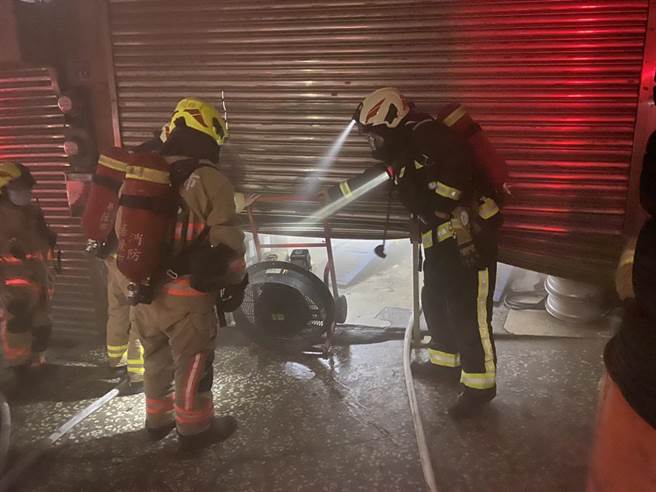 基隆市安乐路一段汽车修配厂发生火警，消防队员利用破坏器材进入厂内灭火。（基隆市消防局提供／张志康基隆传真）