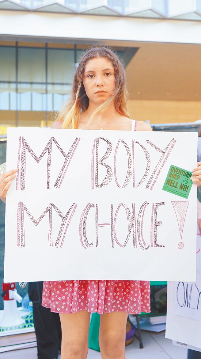 美国联邦最高法院24日推翻宪法保障堕胎权，一名女性示威者在洛杉矶市中心的联邦法院外，手持「我的身体我做主」标语，参加抗议活动。（新华社）