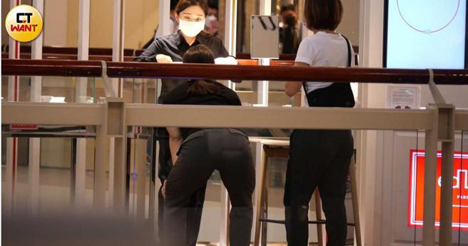 店员指着柜内的饰品，郭婞淳弯腰端详的模样很像是在做运动。（图／本刊摄影组）