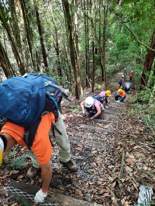 志工们利用假日进行手作步道，一起展开木阶梯止滑条施作。（东势林管处提供）