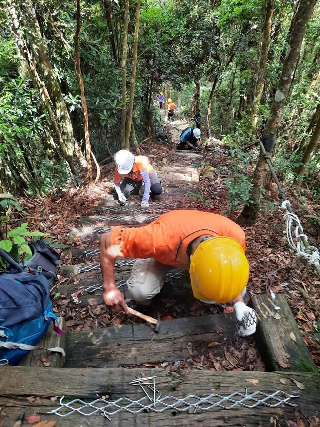 志工们利用假日进行手作步道，一起展开木阶梯止滑条施作。（东势林管处提供）