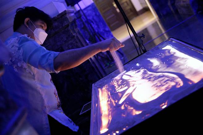 台博馆「水怪－水栖爬行动物化石展」27日举行开展仪式，邀请沙画艺术家马力欧（Mario Rafa Subeldia）现场表演，以沙子绘出各类型的水栖爬行动物。（黄世麒摄）