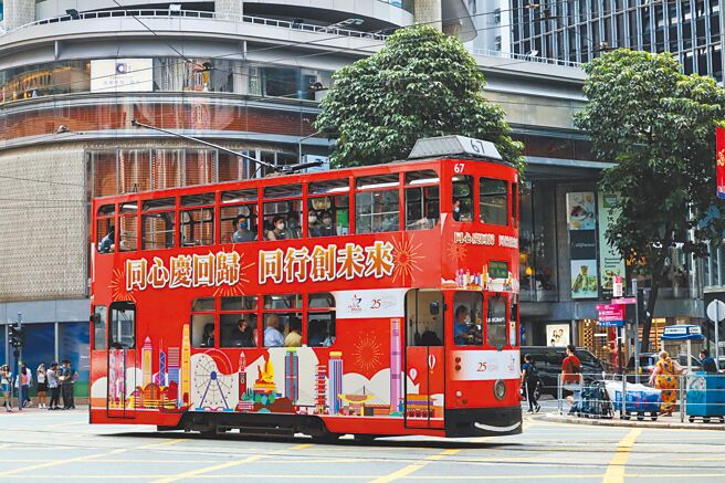 本周五（7月1日）将是香港主权移交中国25周年纪念。图为香港电车车身张贴出「同心庆回归 同行创未来」穿梭闹市的中心。（中新社）